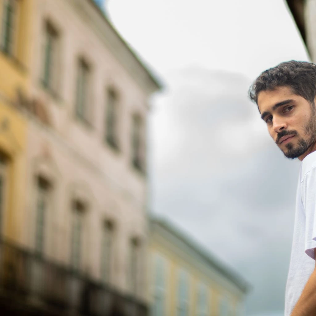 Jovem brasileiro estudando trilha de programação em biblioteca pública